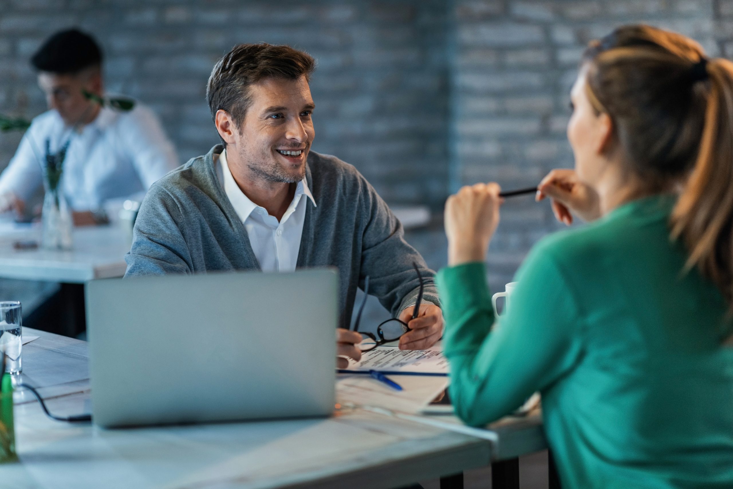 Happy businessman communicating with his female colleague at work.